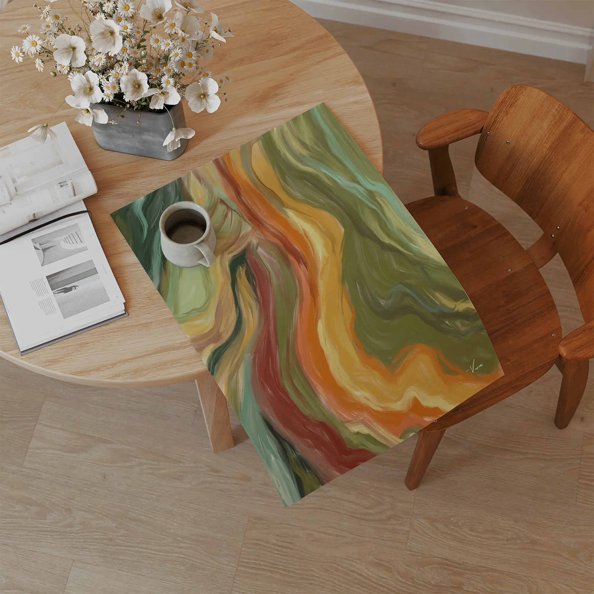 A colorful abstract art print featuring wavy marbled patterns in green, yellow, orange, and red, displayed on a wooden dining chair next to a round wooden table with a coffee mug and an open book.